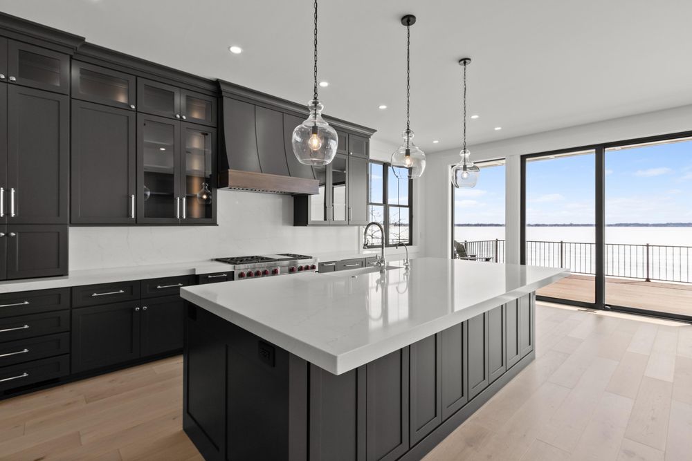 Dark-cabinet kitchen with a large white island and lake view